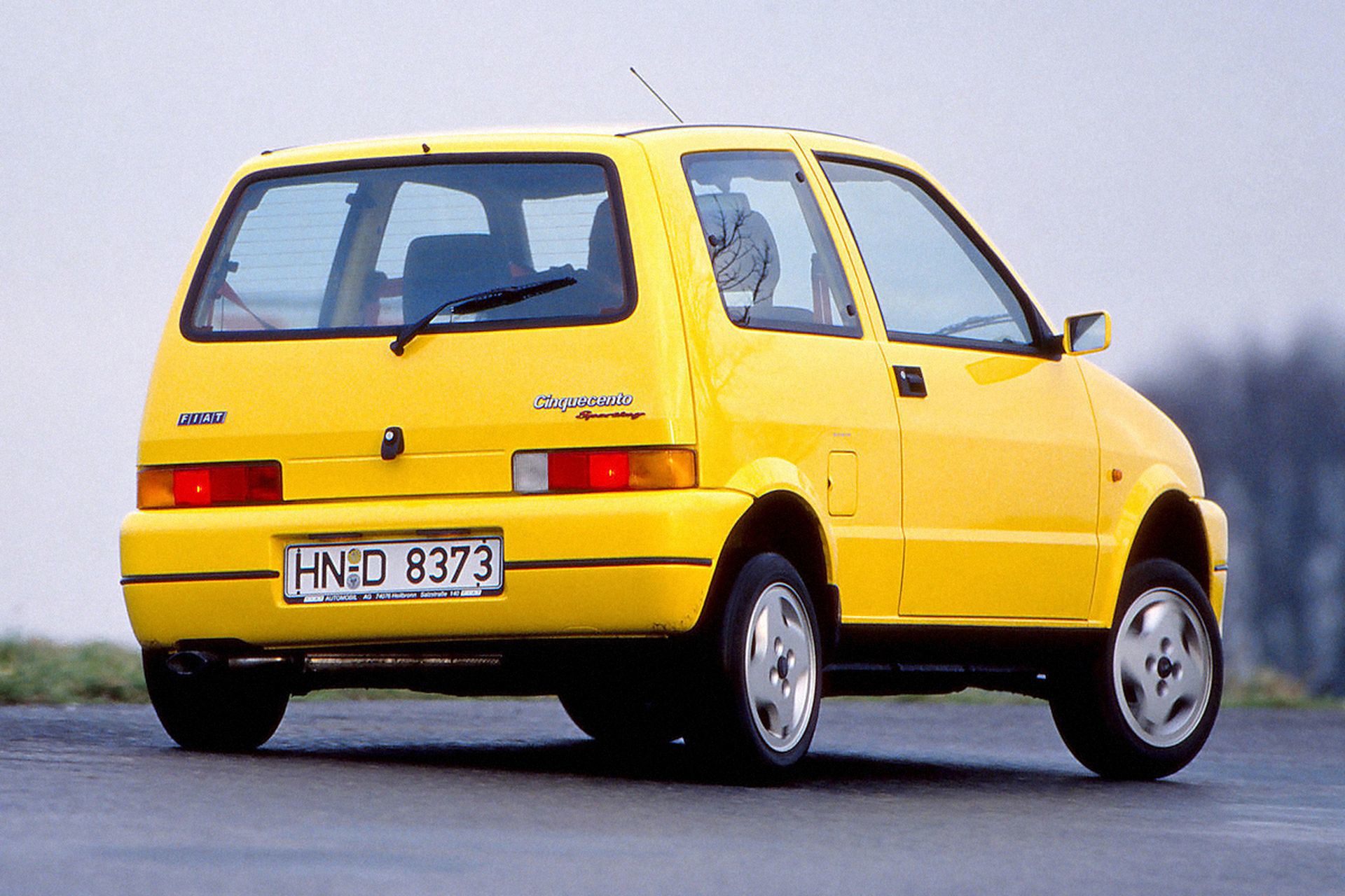 Vista trasera-lateral del Fiat Cinquecento Sporting en amarillo.