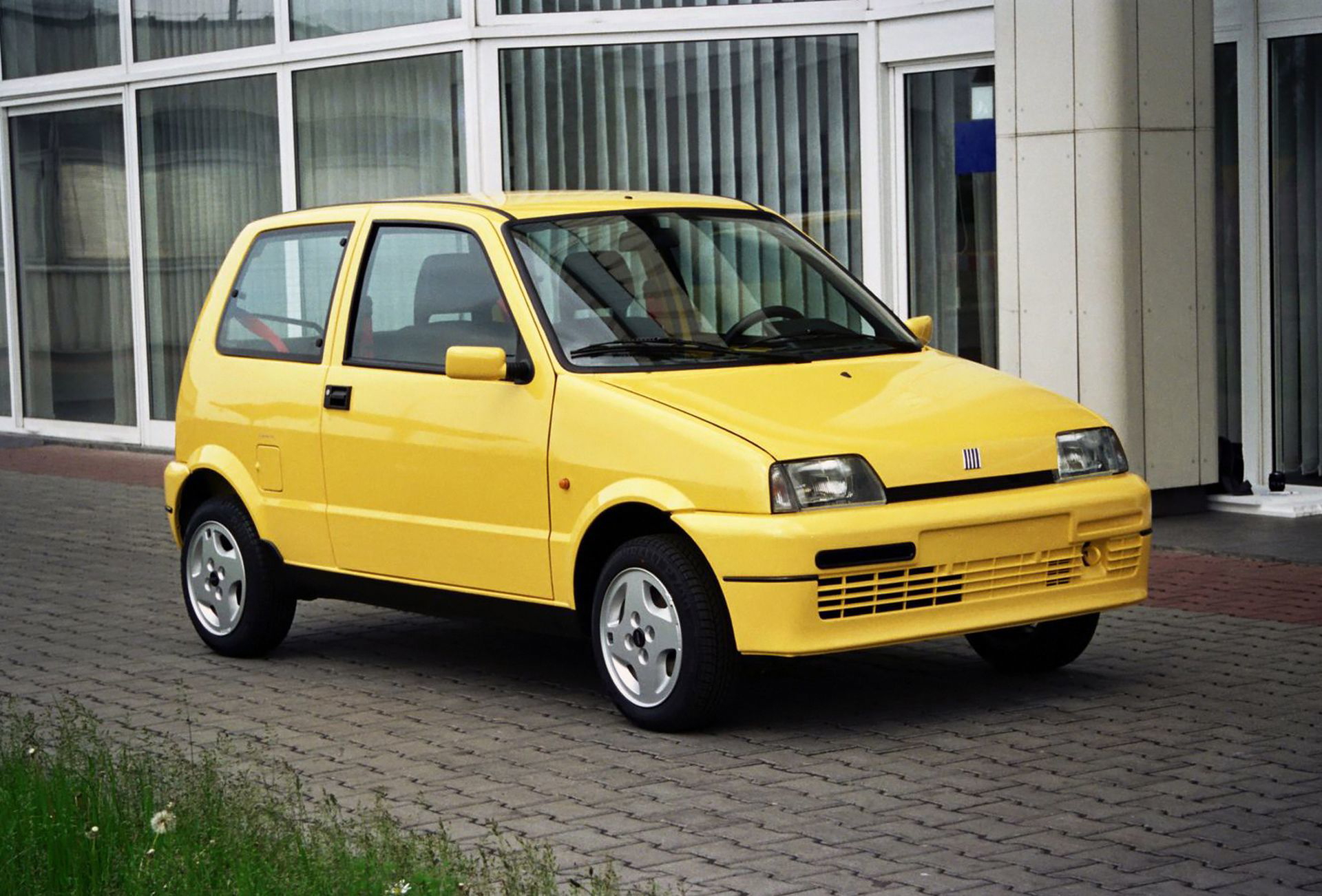 Fiat Cinquecento Sporting en amarillo, vista delantera y lateral.