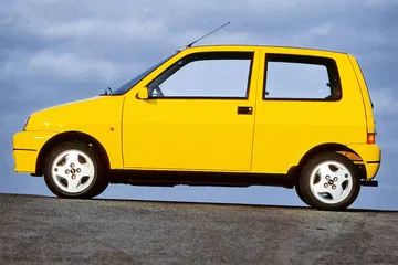 Fiat Cinquecento Sporting en vista lateral, símbolo de agilidad urbana.