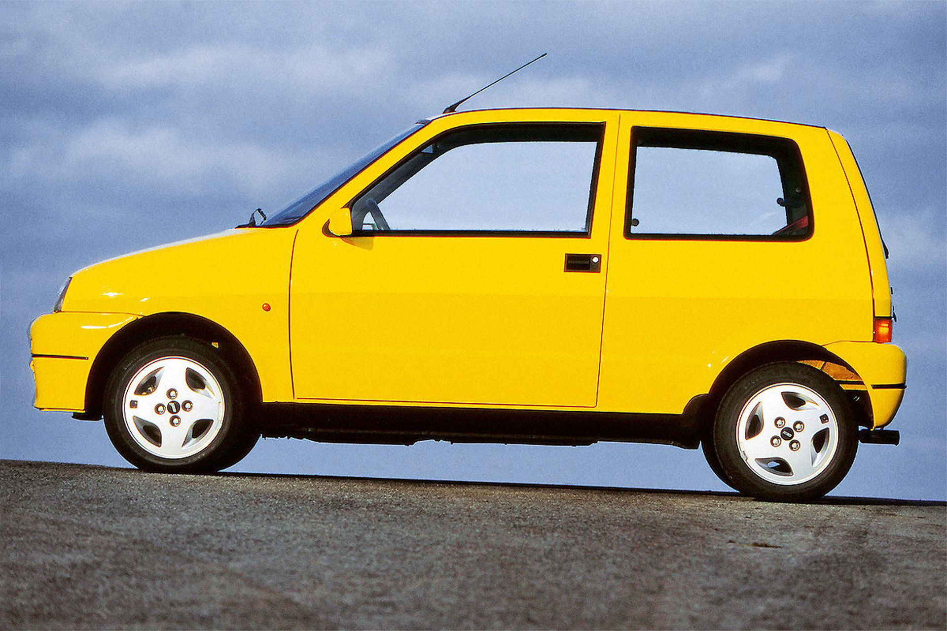 Fiat Cinquecento Sporting en vista lateral, símbolo de agilidad urbana.