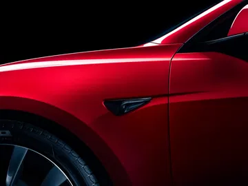 Detalle lateral del Tesla Model 3 enfocando en la línea y diseño.