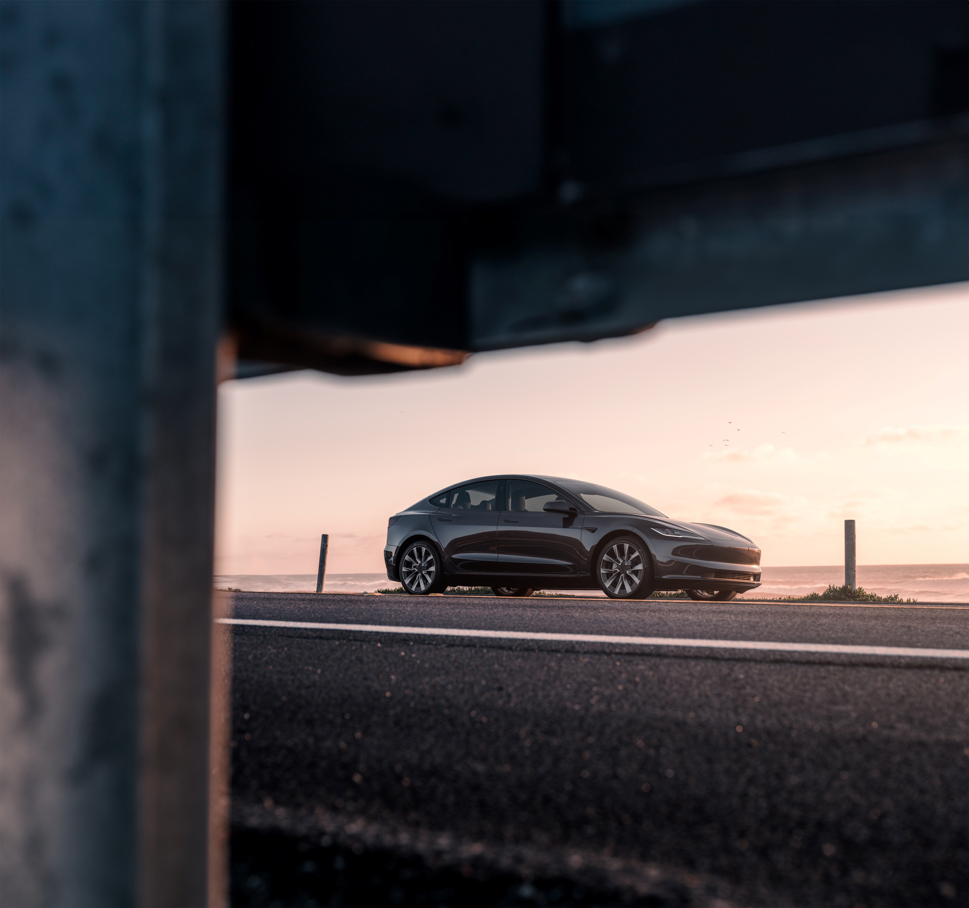 Tesla Model 3 captado al atardecer, destacando su diseño lateral y aerodinámico.