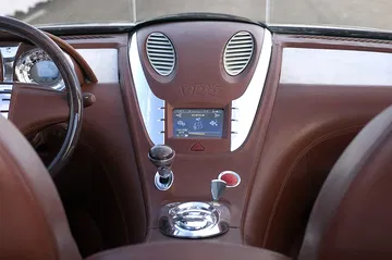 Vista del panel central del Peugeot 907 con indicador V12 y detalles en madera y metal.