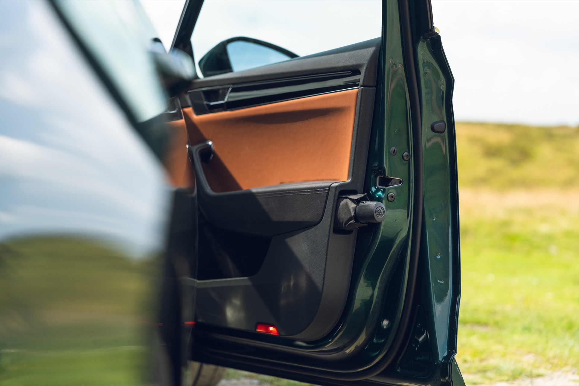 Vista de una puerta abierta del Skoda Superb mostrando acabados y detalles.