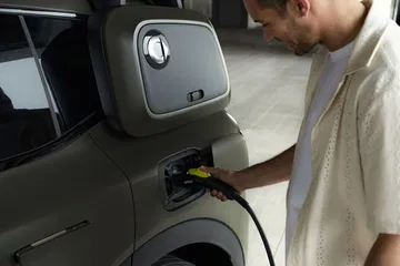 Vista lateral de un smart SUV cargándose, detalle del conector