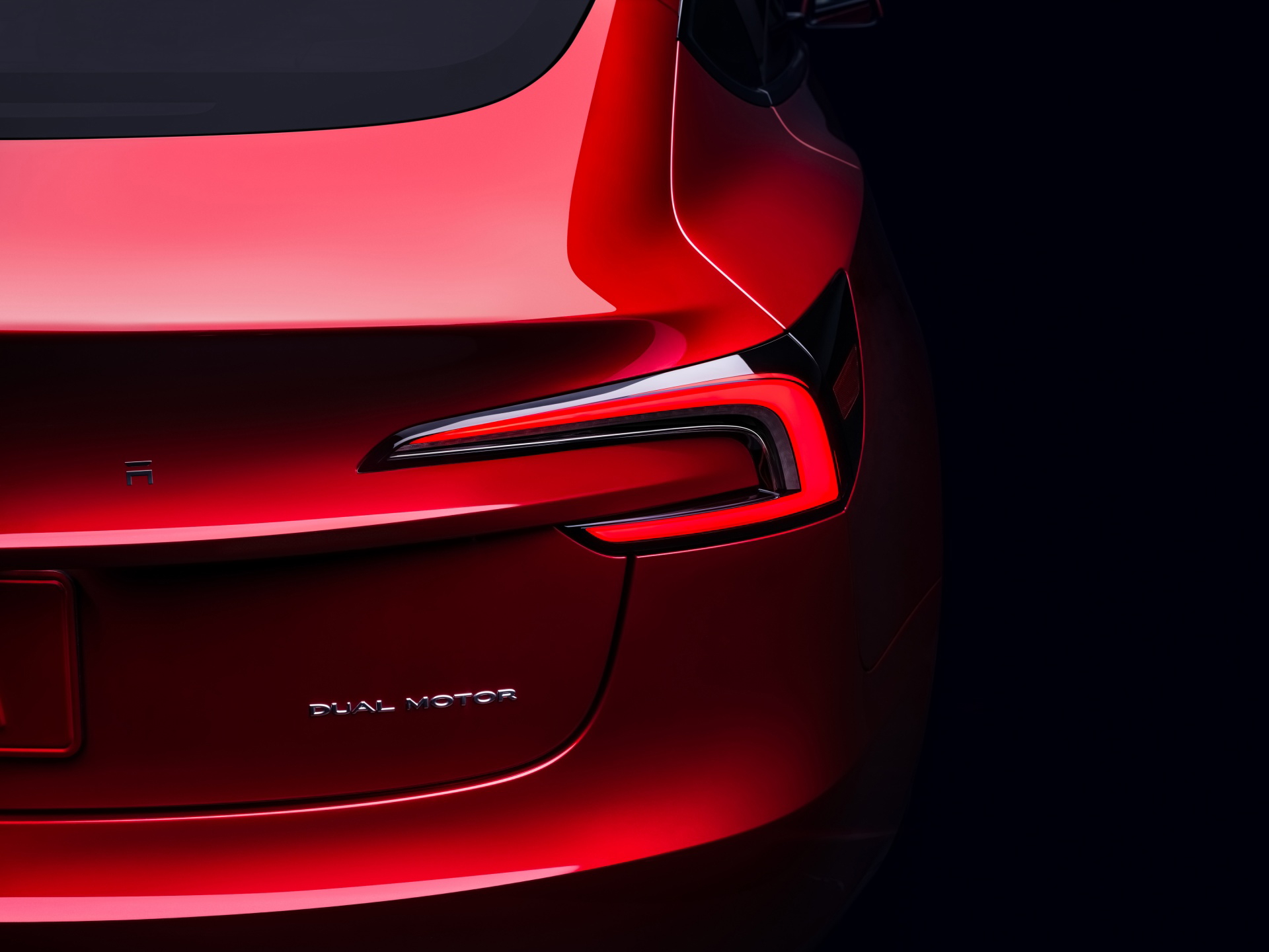 Vista trasera lateral enfocando la luz y diseño aerodinámico del Tesla Model 3.