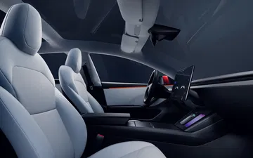 Vista lateral interior del Tesla Model 3 enfatizando su diseño minimalista y elegantes asientos