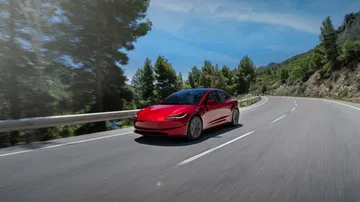 Tesla Model 3 en movimiento mostrando su dinámica lateral y diseño aerodinámico.