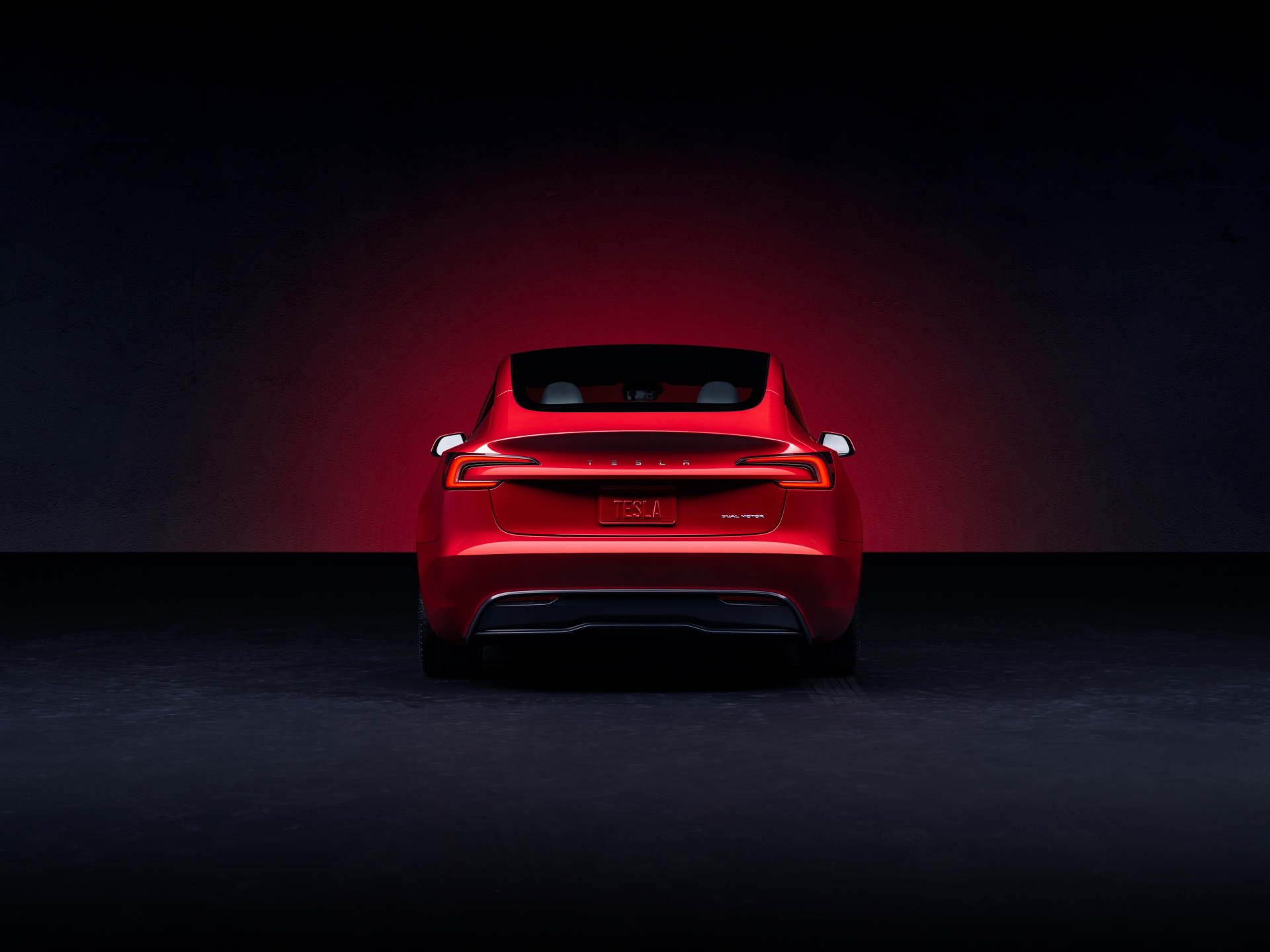 Perspectiva trasera del Model 3 iluminado, destacando su diseño sofisticado.