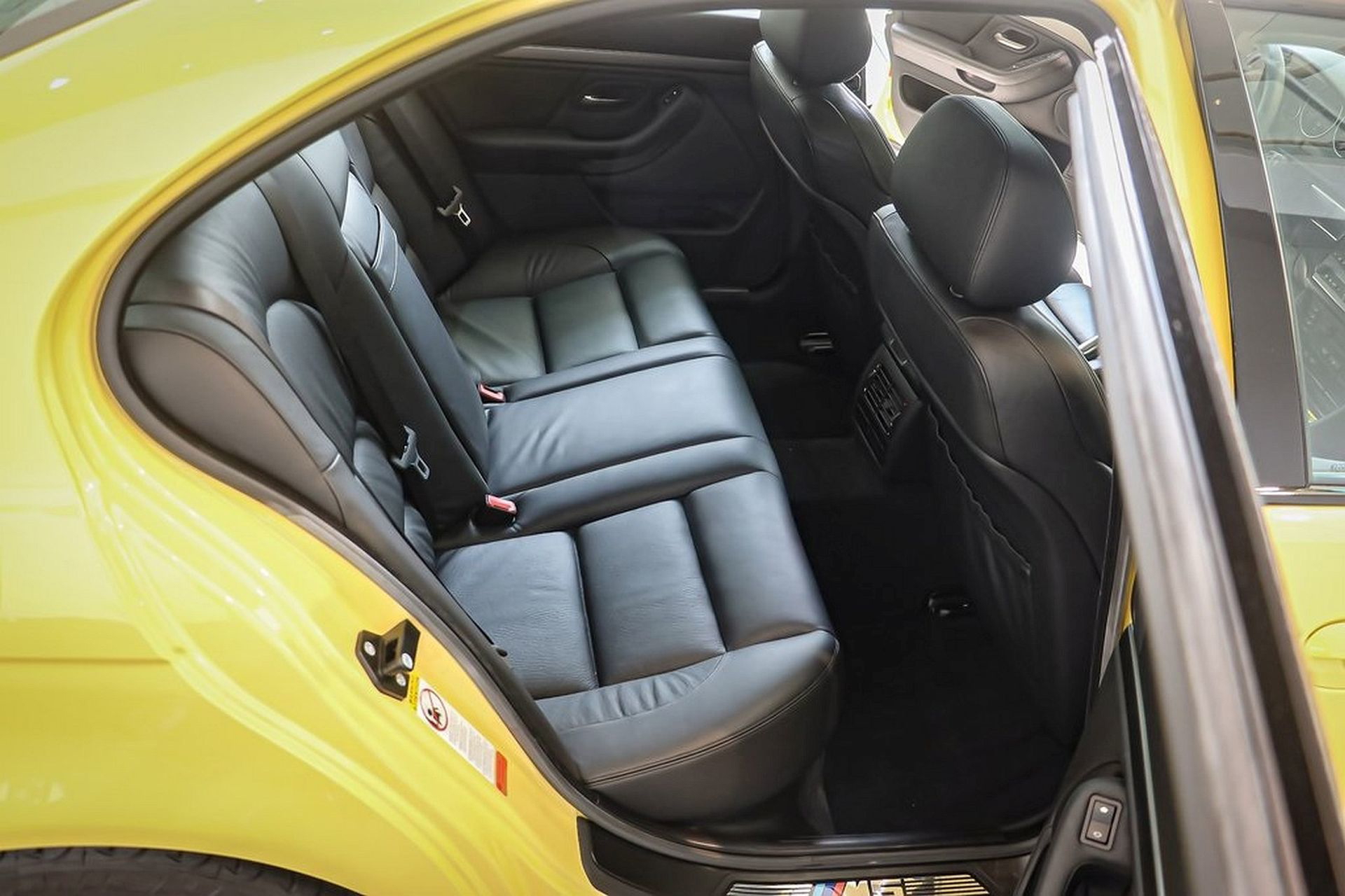 Vista lateral BMW M5 E39 en amarillo, icono de deportividad