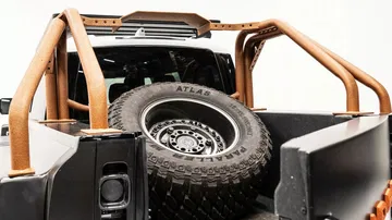 Vista de un Land Rover Defender 6x6 con rueda de repuesto trasera.