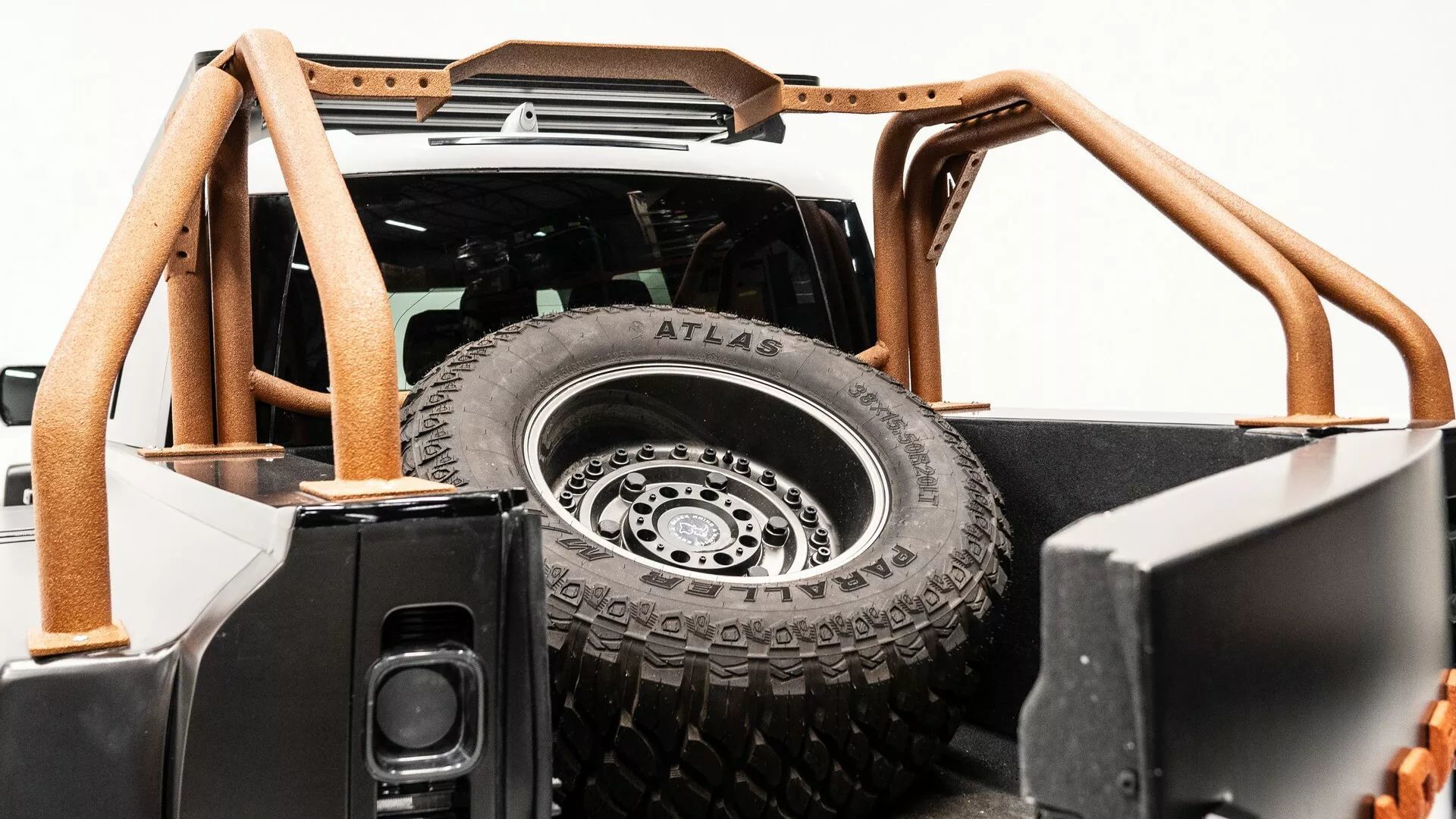 Vista de un Land Rover Defender 6x6 con rueda de repuesto trasera.