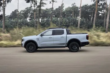 Vista lateral de la nueva Ford Ranger PHEV Stormtrak avanzando robusta y silenciosamente.
