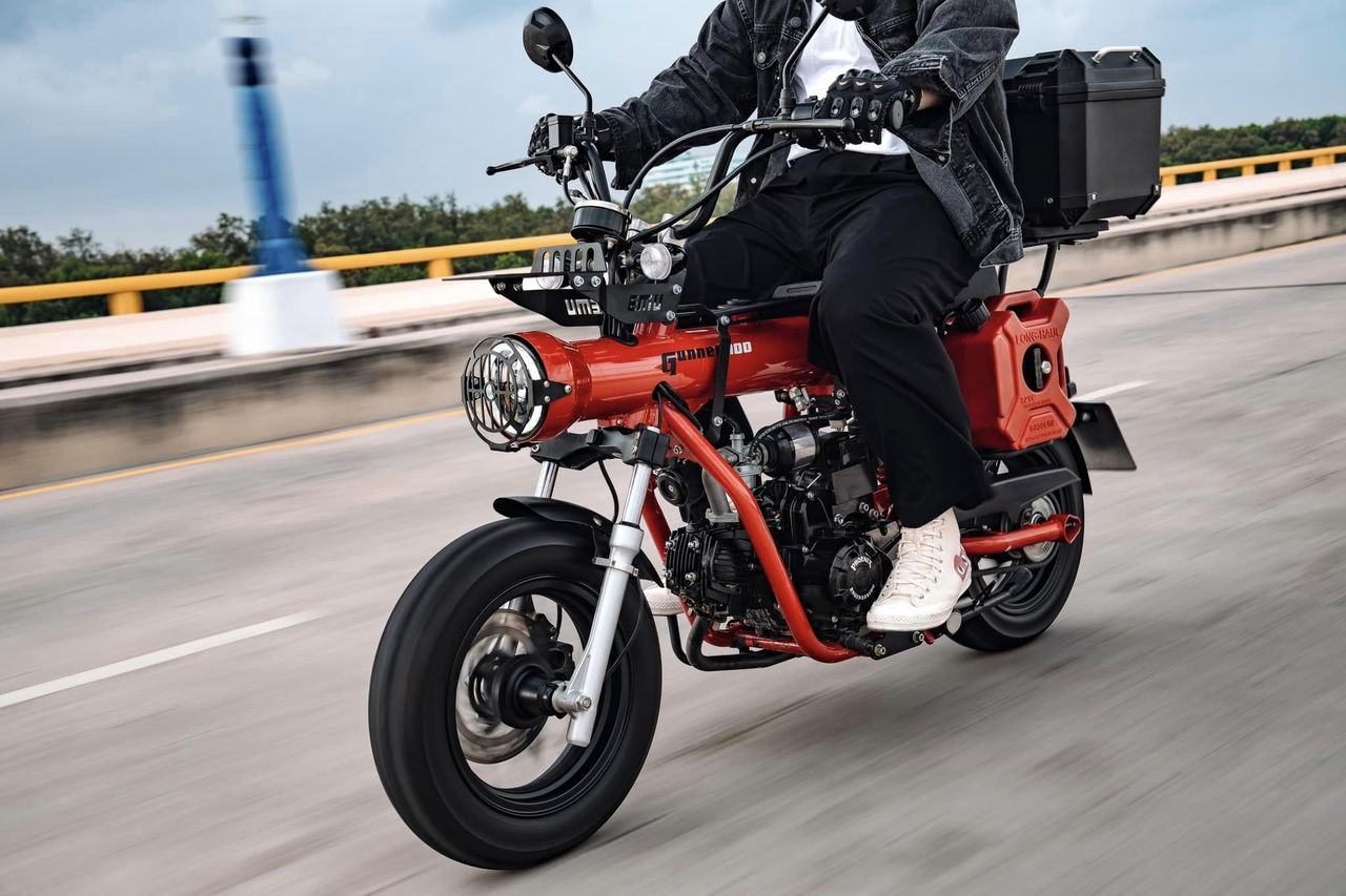 Vista dinámica de la motocicleta Gunner 50 en movimiento, destacando su diseño lateral.