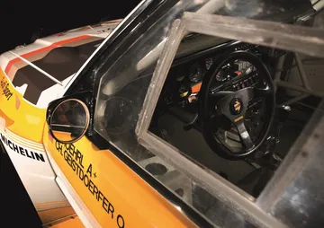 Vista lateral del cockpit de un vehículo de rally, evocando la era dorada de los 5 cilindros.