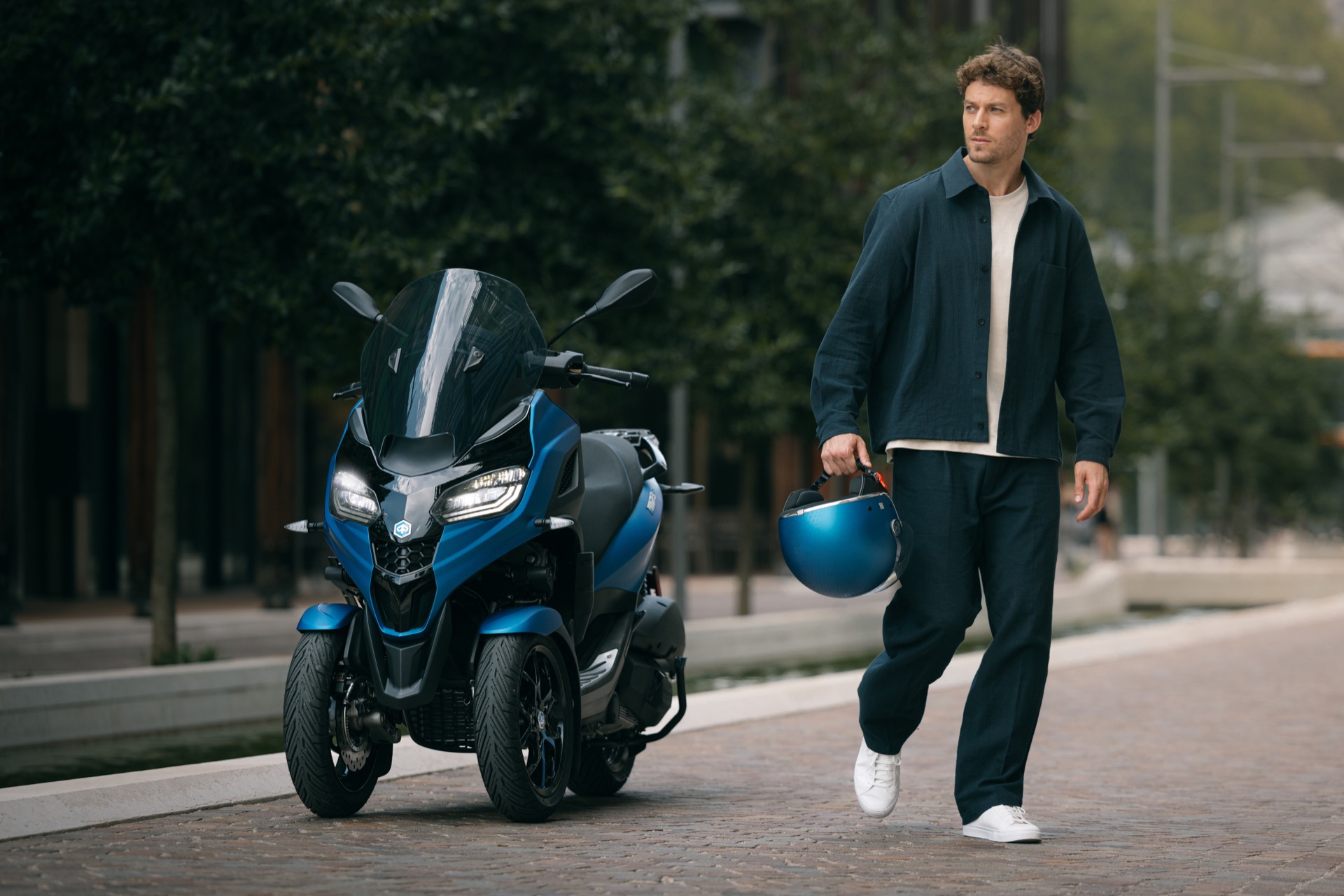 Vista delantera y lateral de la Piaggio MP3 2024, mostrando su diseño trirrueda.