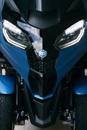 Vista cercana del sistema de tres ruedas del Piaggio MP3 310 2024, innovación y seguridad.