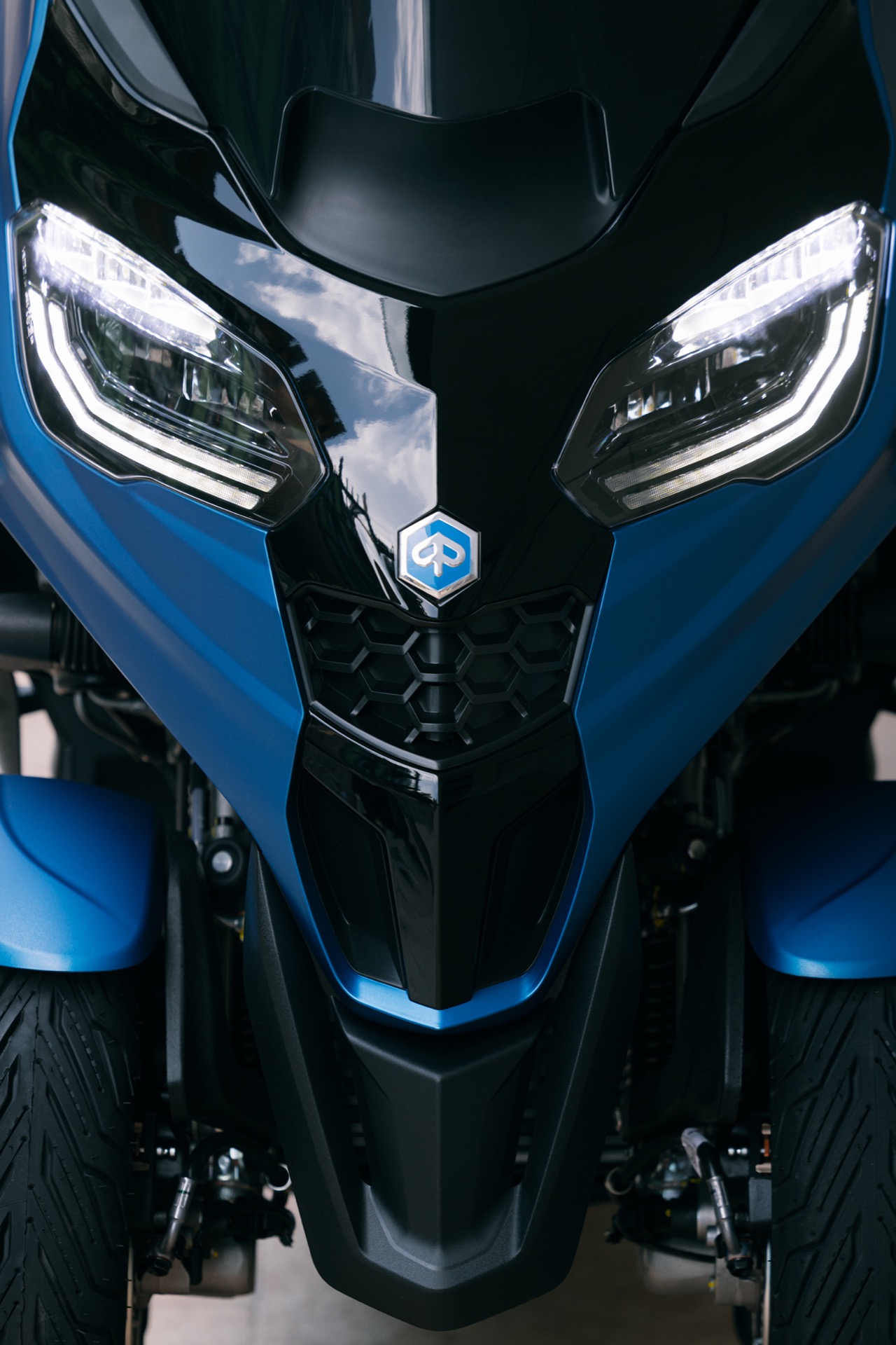 Vista cercana del sistema de tres ruedas del Piaggio MP3 310 2024, innovación y seguridad.