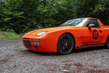 Vista lateral de un Porsche naranja estacionado al aire libre