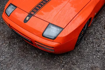 Vista aérea del frontal y capó de un Porsche, destacando su diseño icónico.