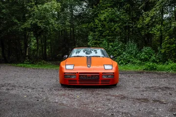 Vista frontal y lateral de un Porsche clásico en color naranja.