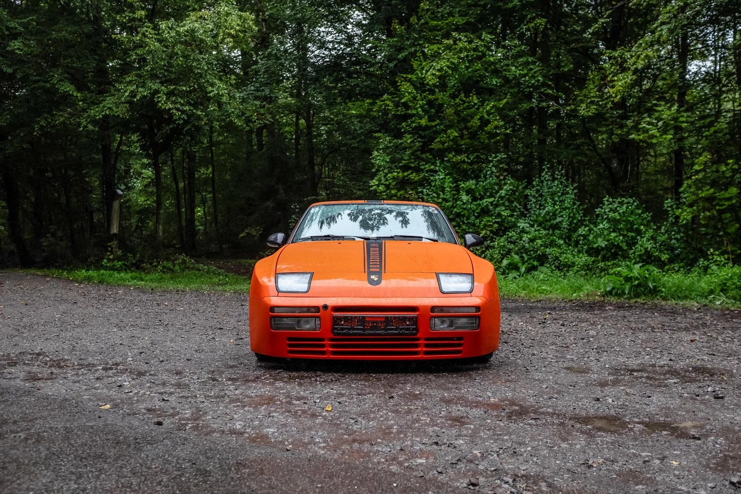 Vista frontal y lateral de un Porsche clásico en color naranja.