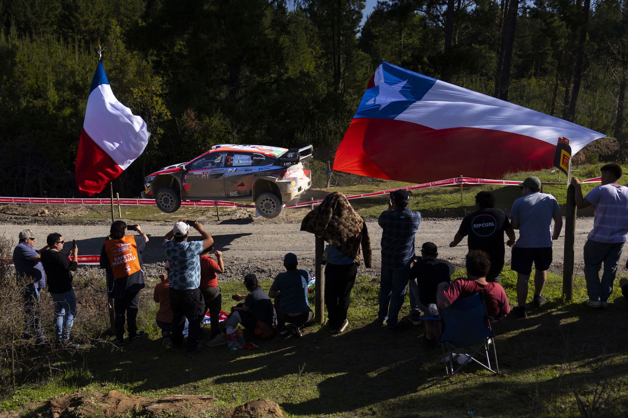 Vehículo de competición en acción durante el Rally de Chile 2024, rodeado de aficionados.