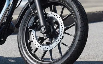 Primer plano de la rueda de una moto Honda estilo retro, destacando su diseño clásico.