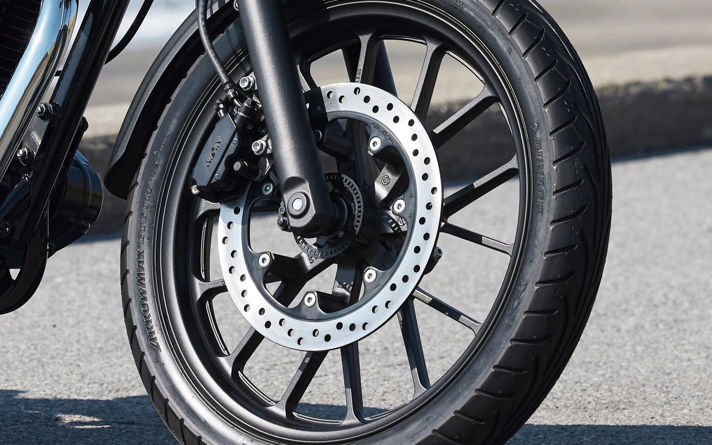 Primer plano de la rueda de una moto Honda estilo retro, destacando su diseño clásico.