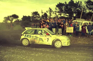 El Ibiza Kit Car en acción, competencia de rally con emblema SEAT y público de fondo.