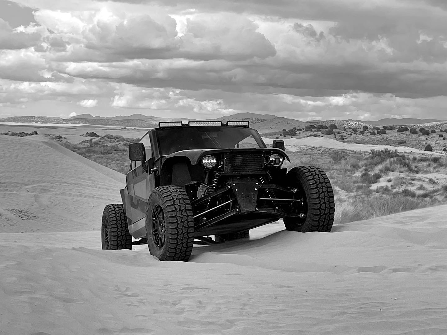 Vehículo 4x4 compacto mostrando su capacidad todoterreno en terreno arenoso.