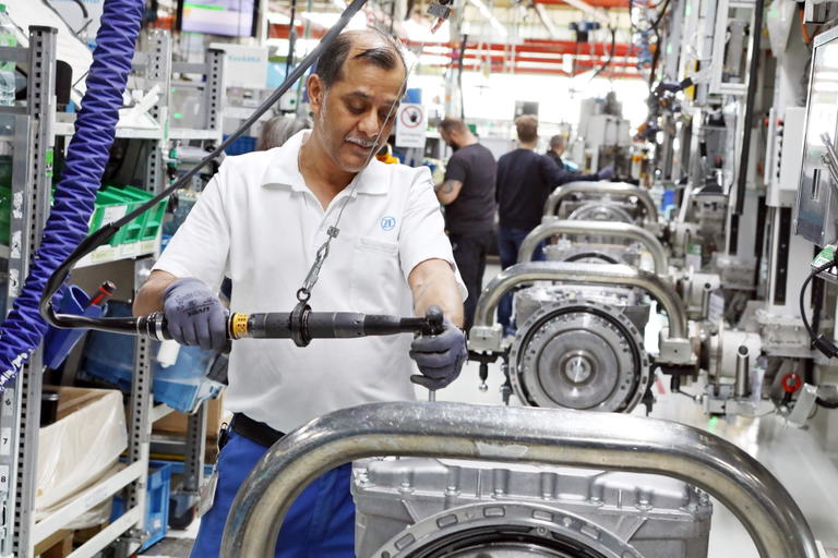 Empleado ensamblando componentes cr&iacute;ticos en la l&iacute;nea de producci&oacute;n.