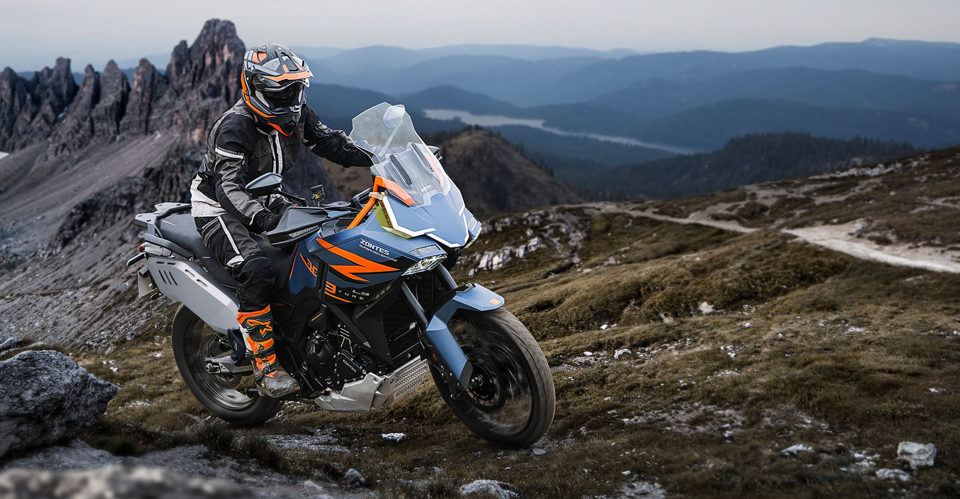 Trail Zontes 703F en paisaje montañoso, exhibiendo su perfil agresivo y estilizado.