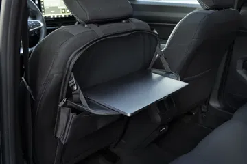 Vista de la bandeja trasera plegable integrada en el asiento del Dacia Bigster.