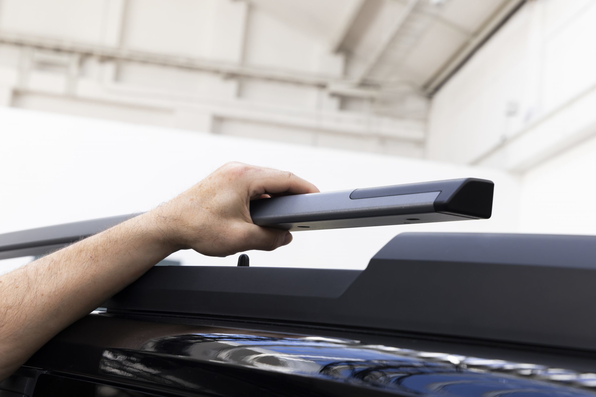 Mano ajustando sistema de transporte en techo de Dacia Bigster