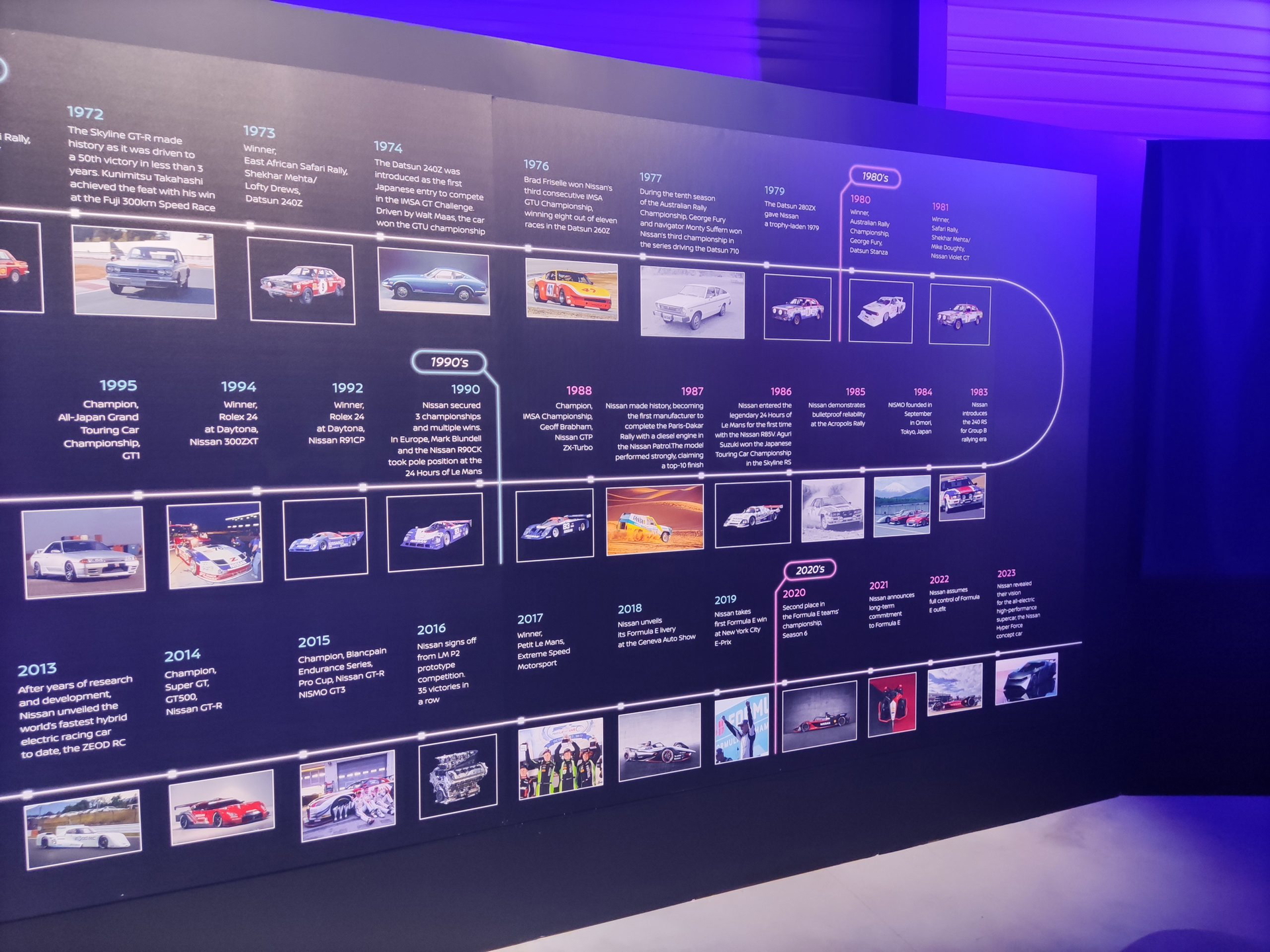 Vista de una exhibición histórica de modelos de Nissan con descripciones visuales.