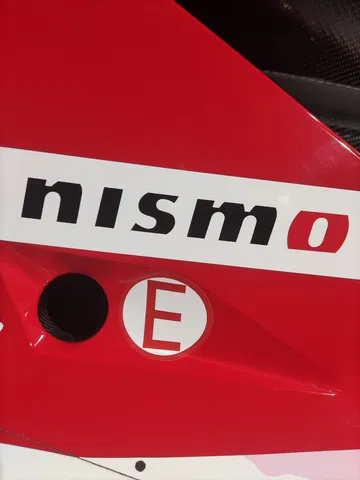 Vista cercana del distintivo 'NISMO' en componente de Nissan