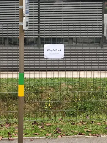 Cartel #IvryOnTrack colocado en un entorno urbano, detalle curioso.