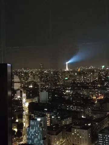Vista nocturna de la Torre Eiffel iluminando el cielo de París