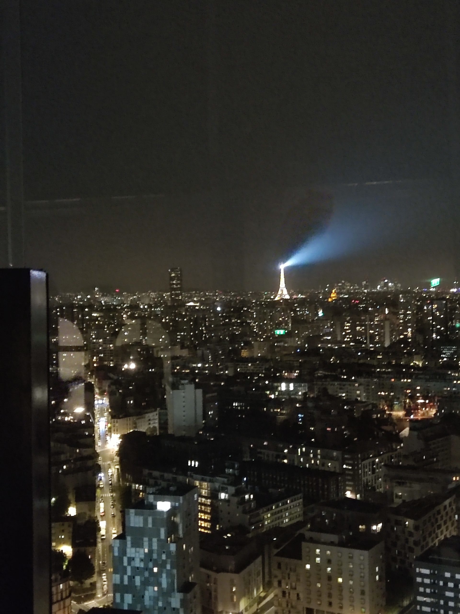 Vista nocturna de la Torre Eiffel iluminando el cielo de París