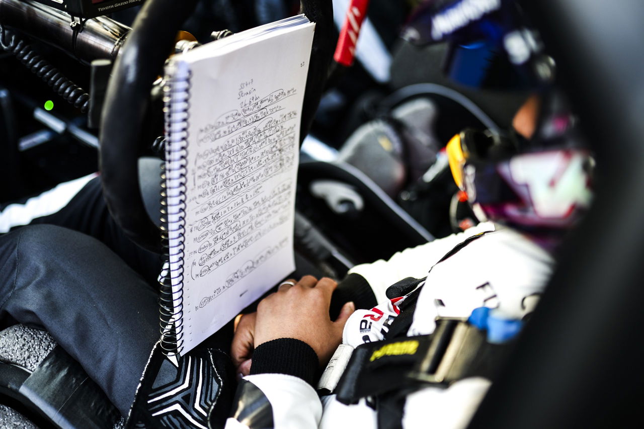 Piloto consultando su libreta de notas antes de la carrera