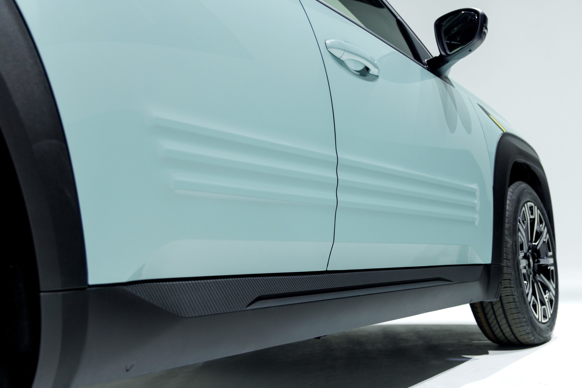 Vista lateral del pequeño SUV Renault 4, mostrando líneas modernas y dinámicas.