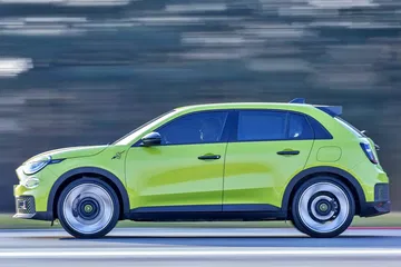 Vista dinámica del Abarth 600e en movimiento demostrando su estilizada silueta.