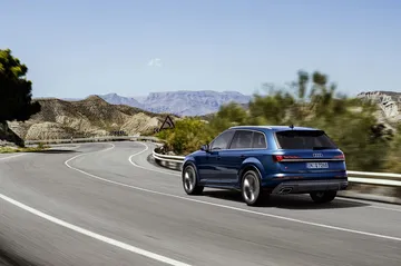 Vista dinámica de la trasera y lateral del Audi Q7 2024 en carretera.