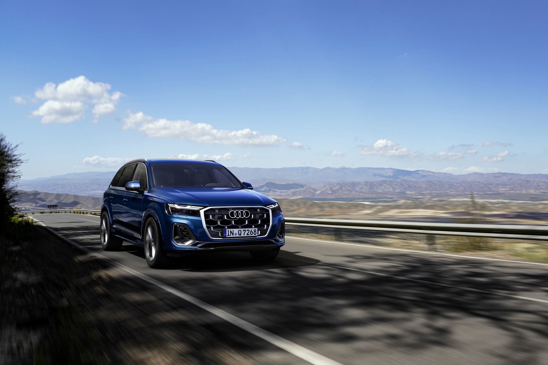 Vista delantera y lateral del Audi Q7, mostrando su imponente presencia en carretera.