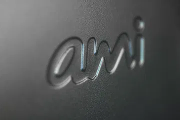 Vista del logotipo 'ami' destacando en relieve sobre superficie texturizada.