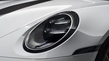 Primer plano del faro del Porsche 911 GT3, diseño icónico y tecnología LED.