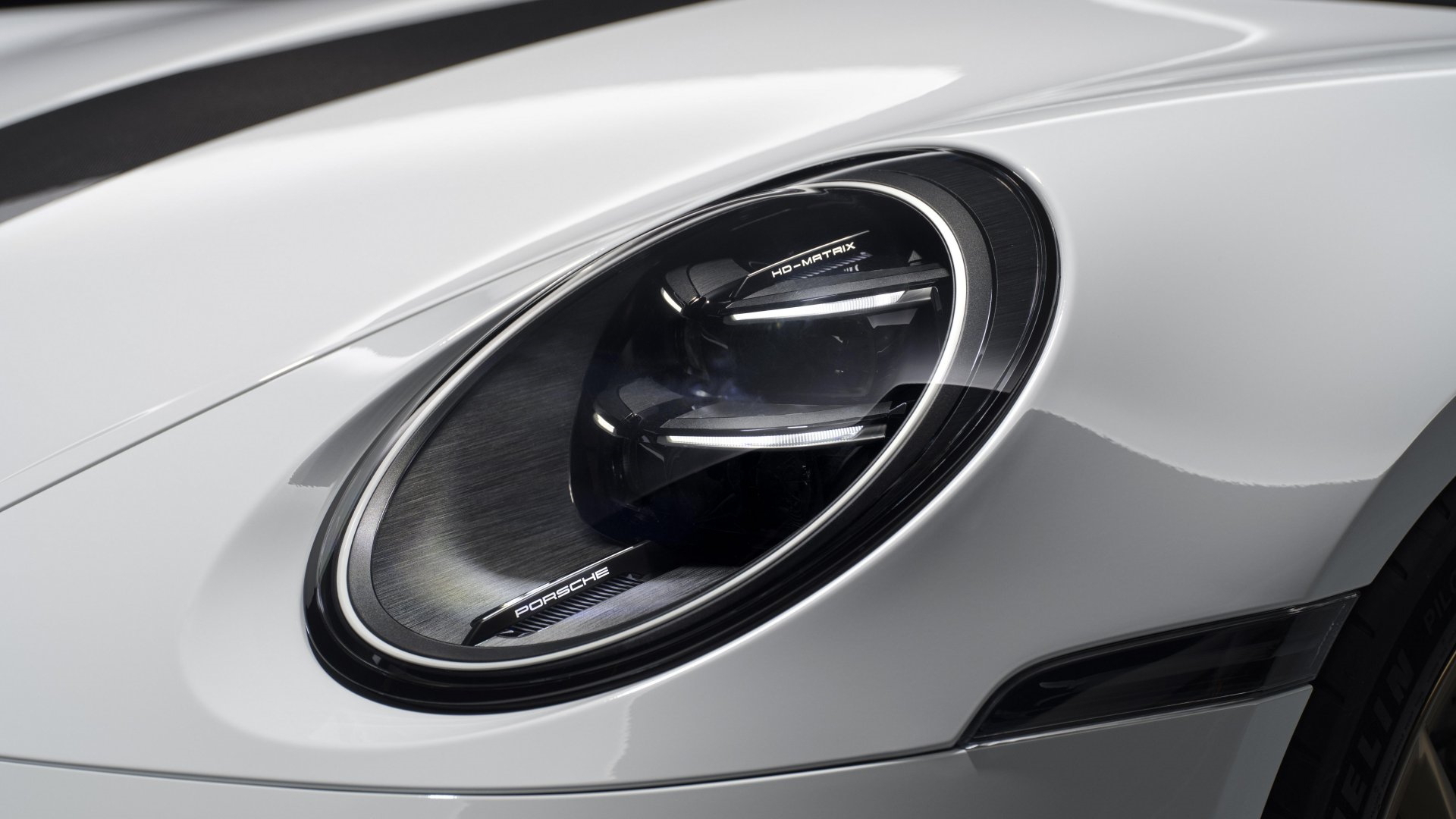Primer plano del faro del Porsche 911 GT3, diseño icónico y tecnología LED.