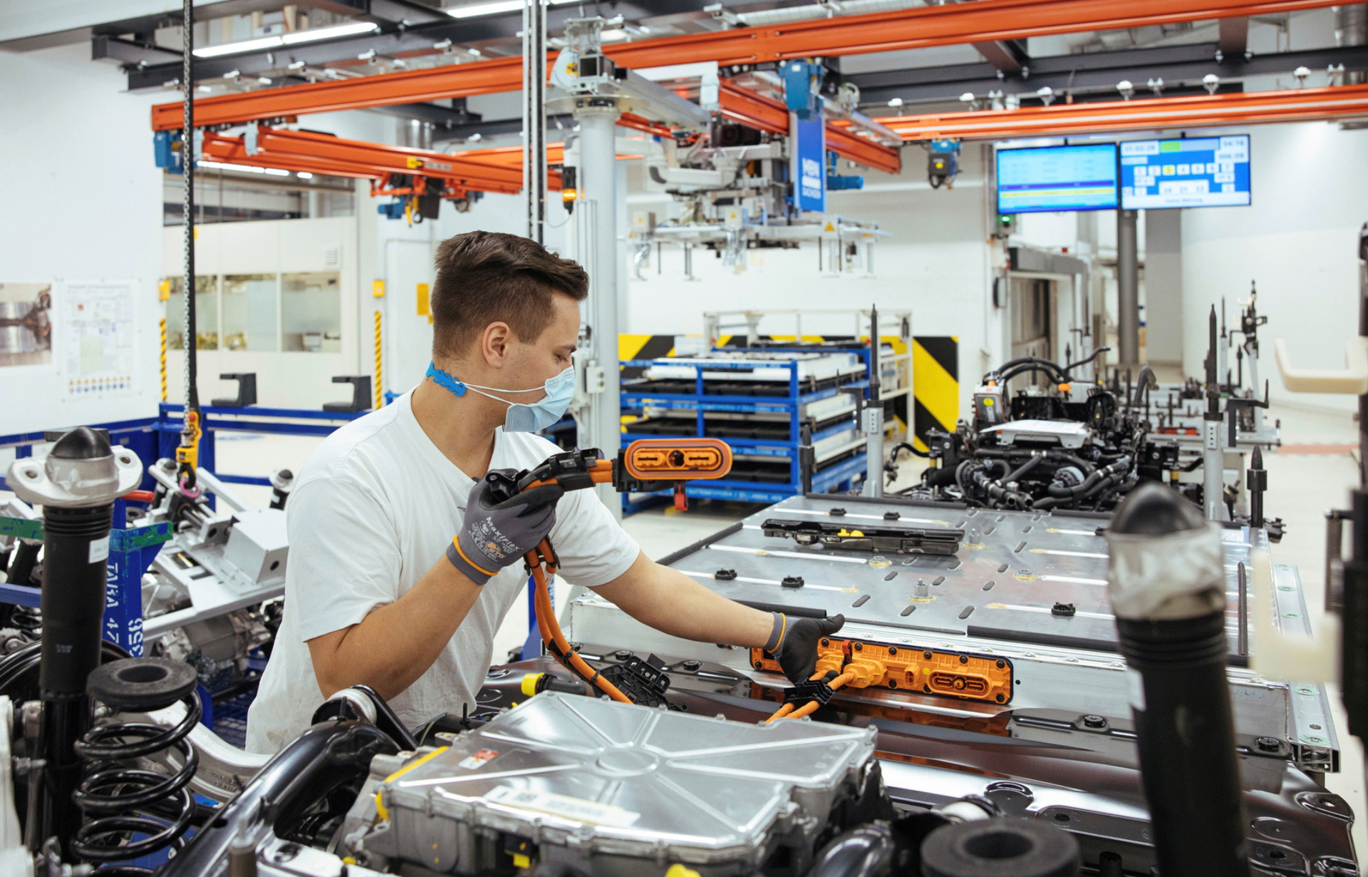 Trabajador en línea de montaje Volkswagen, enfoque en proceso de producción.