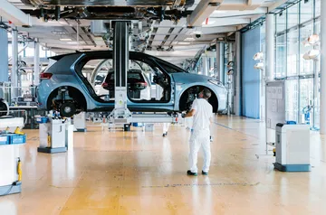 Vista lateral de un vehículo en línea de ensamblaje en planta Volkswagen.